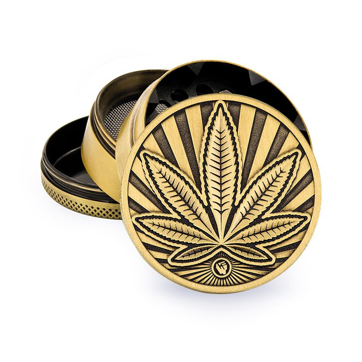 Goldener FireFlow Metall-Grinder 4-teilig mit geprägtem Hanfblatt und Strahlen Motiv